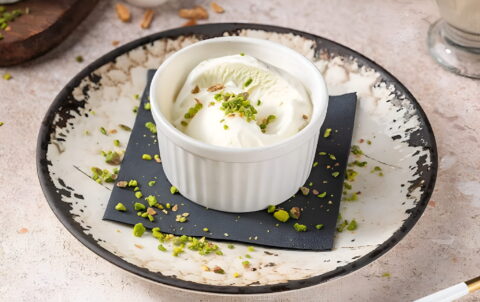 Traditional Turkish ice cream served in a white ramekin topped with crushed pistachios at Hatay Turkish Restaurant, Abu Dhabi.
